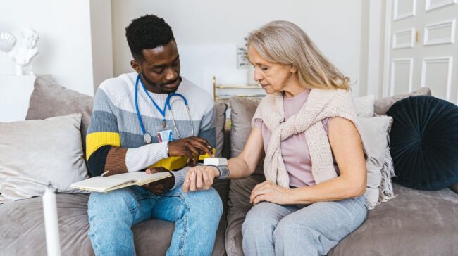 Healthcare professional checking blood pressure of elderly woman in a cozy indoor setting. - Photo by Antoni Shkraba on Pexels
